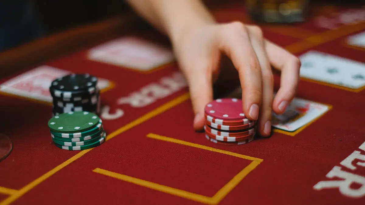 Hand moving casino chips to illustrate playthrough calculations