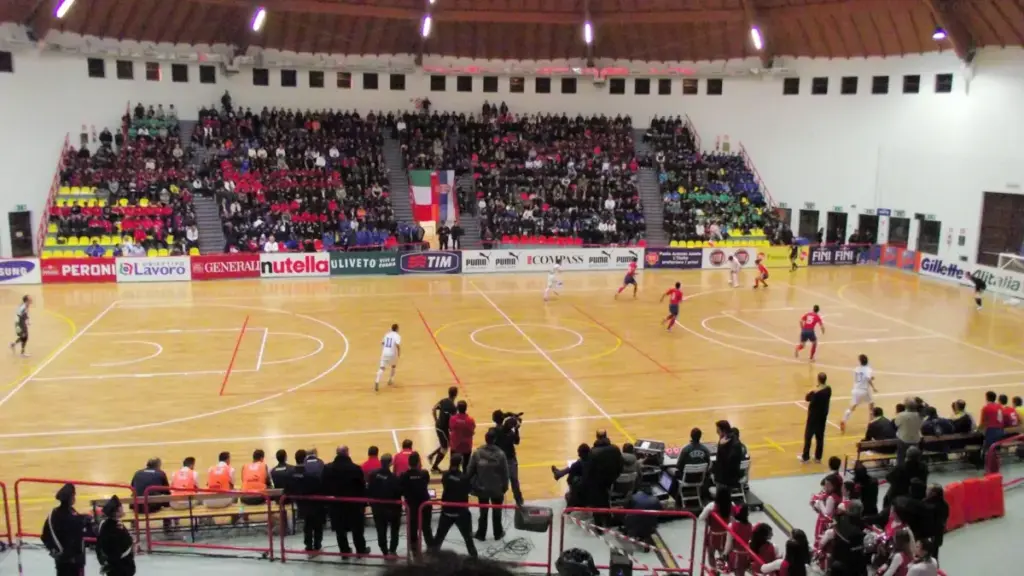 Futsal players competing on an indoor court